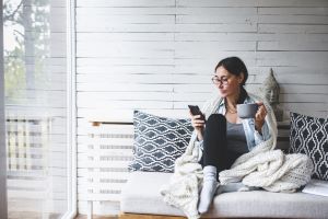 Woman on couch using phone